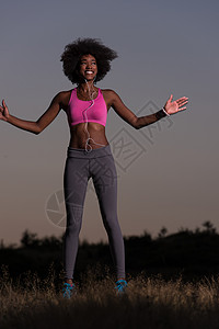 美国赛跑者黑人妇女正在做伸展锻炼 放松和温暖日落运动草地身体运动员女士跑步成人活动慢跑者背景