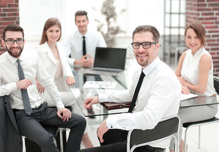 老板和企业团队坐在他们的办公桌旁男人技术人士职场营销讨论同事讲话窗户桌子背景图片
