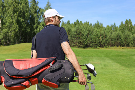高尔夫球手在夏季打高尔夫比赛中走来走去并背着袋子上课微笑玩家课程活动成人球童游戏闲暇晴天肩膀背景图片