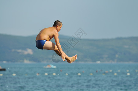 潜水男孩男孩跳海空气热带技巧波浪游泳喜悦旅行孩子天空游泳者背景