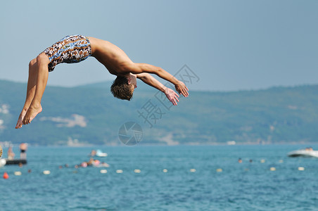 男孩跳海潜水闲暇青年热带活力身体海滨海洋自由喜悦背景图片