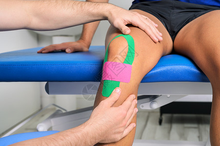 弹力绷带生理治疗师在男性病人膝盖上应用了动脉胶带 Kinesilogy 物理治疗 康复概念理疗胶带职业医疗医学绷带卫生药品治疗师医生背景