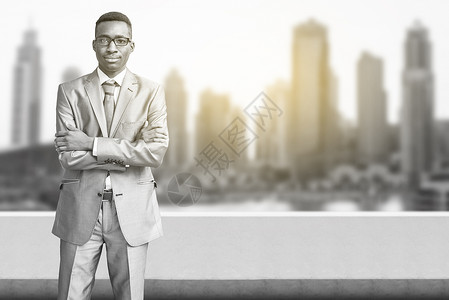 年轻黑人商务人士 在大城市前的盛大城市面前建筑学商业建筑物公园套装高楼日光场景黑发人士背景图片