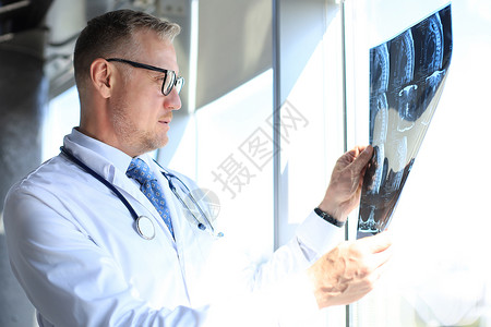 医生治疗师仔细看X光片x光保健援助医师病人专家疾病外科卫生医院图片