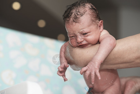 刚出生的女婴第一次洗澡女儿保健妈妈父母幸福浴缸母亲卫生童年女孩背景