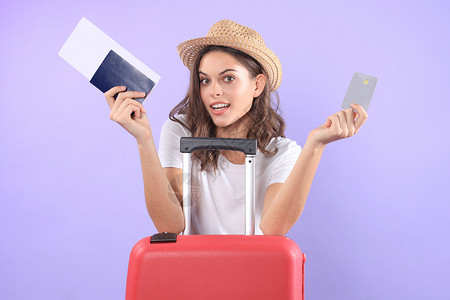 穿暑期临时服装的年轻旅游女孩 带太阳眼镜 红色手提箱 紫底护照和孤立的紫底护照手提包航空公司航程冒险紫色休息闲暇案件飞机场旅游背景
