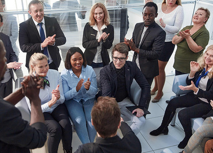 办公室雇员坐在椅子拍手上 在闭幕式小组会议上向演讲人或发言者致意商业微笑商务人士动机扬声器男人商界会议经理背景图片
