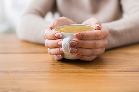 在咖啡馆里喝咖啡的近身妇女厨房毛衣温暖天气季节咖啡巧克力木头杯子女性图片