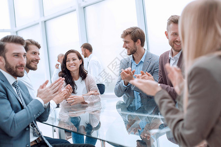 一群商业界人士鼓掌鼓掌坐在谈判桌旁欢呼图片