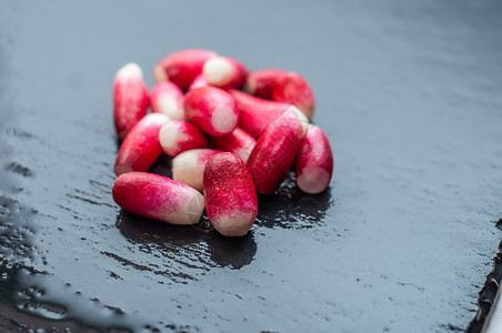 一小堆红皮萝卜 在潮湿的黑石背景上生态维生素饮食营养蔬菜年度石头红色沙拉免疫背景图片