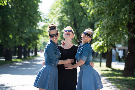 三个年轻美女的肖像 戴墨镜的太阳镜头发双胞胎情绪乐趣女孩们团体快乐黑发女士朋友们背景图片
