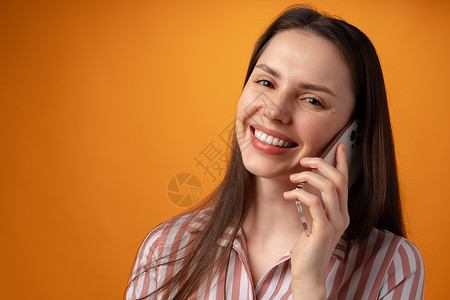年轻女性在黄色背景下通过电话交谈的演播室照片手机工作室女孩女士成人黑发头发背景图片