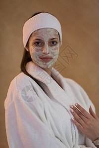 漂亮的年轻女孩戴面罩施用面罩的斯帕妇女沙龙女孩成人工作室女士身体肤色治疗皮肤护理背景