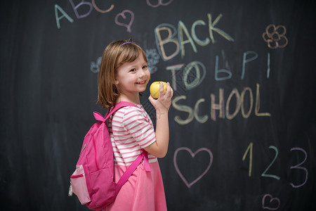 粉色背包带苹果和回学校做背景绘画的快乐儿童女孩幼儿园幸福学生教育瞳孔数字学习知识背包背景