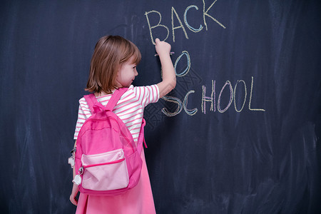 背书包去学校背背背书写黑纸板的女童粉笔黑板教育粉色知识瞳孔女孩写作背包孩子们背景