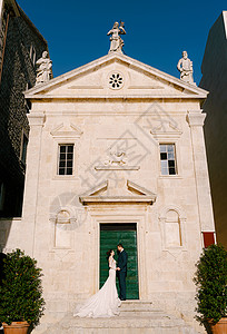 新新娘和新郎站在圣门徒马克天主教堂的台阶上 黑山佩拉斯特背景图片