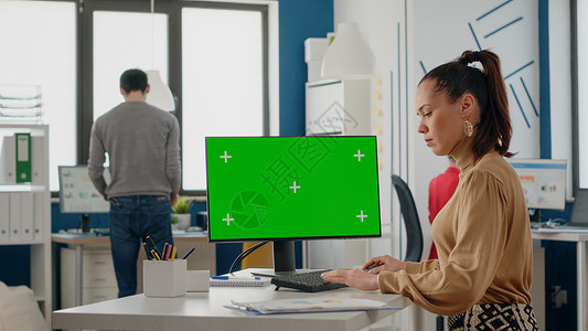 员工在电脑上使用绿屏公司色度屏幕桌子女士互联网网络桌面同事监视器背景图片
