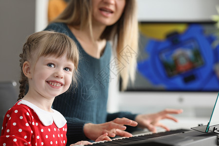 钢琴会漂亮快乐的小孩 会跟妈妈一起弹钢琴消遣钢琴知识微笑按钮艺术家喜悦学习旋律情绪背景