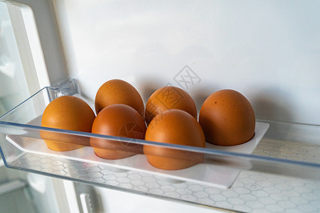 棕色鸡蛋冰箱里半打鸡蛋 6个棕鸡蛋 在空的口腔冰箱里背景
