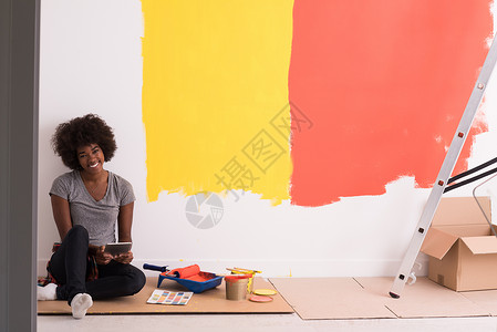 颜色房间坐在地板上的后背女画家女孩工作设计师房子快乐画笔房间绘画维修成人背景