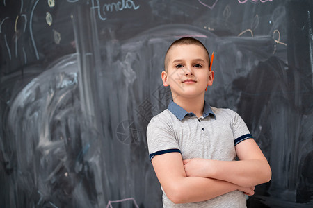 小男孩在黑板前的肖像孩子学校班级微笑耳朵课堂教学男生橙子黑色图片