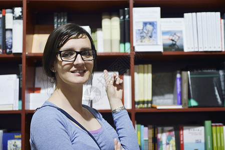 图书馆中的女性店铺学生书架青年架子女孩女士教育文学微笑图片