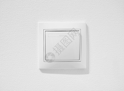 家电开关廉价简单的单极电灯开关 反对白色墙壁的便宜的塑料按钮开关 家里的白色普通拨动开关 用于排气扇或照明应用的标准翘板开关背景