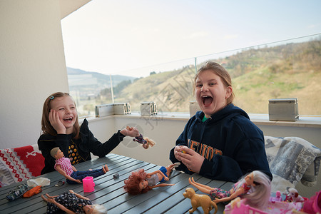 小女孩玩玩洋娃娃孩子桌子朋友们婴儿姐妹学校隔离童年玩具女孩们图片