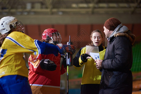 曲棍球女孩与教练员举行青少年冰冰冰球运动员小组会议团体世界学校运动头盔朋友人群商业蓝色教育背景