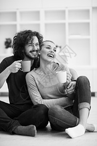 年轻夫妇在新家里咖啡微笑男性地面成人公寓装饰已婚女士白色背景图片