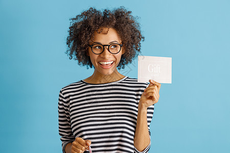 30元代金券带着礼品卡站在工作室的开心女人背景