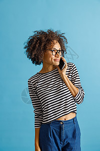 微笑的女人在工作室用手机说话图片