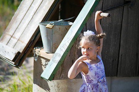提着水桶的女孩乡村风格的漂亮小女孩 离家很近 感到惊讶花园童年空气情感村庄民间红衣女孩场地农场背景