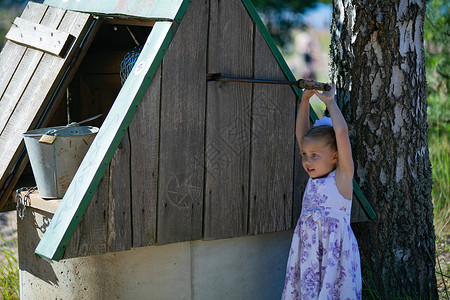 提着水桶的女孩乡村风格的漂亮小女孩 离家很近 感到惊讶村庄空气戏服国家情感童年场地农场农村树木背景