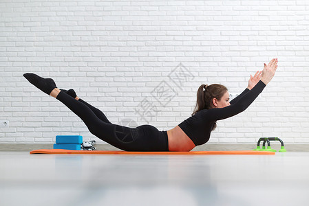 脊柱弯曲女孩在家中做家务锻炼 以强化她的背部臀部运动装工作弓步瑜伽班级微笑成人勃起重量背景