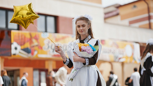 毕业钟声敲响在学校的最后一天 俄罗斯女学生带着气球快乐假期女性头发工作室女士城市孩子们乐趣生活青少年背景