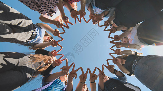 一群女孩用手指来做圆圈社区友谊团队青少年学校孩子帮助合作手势女性图片