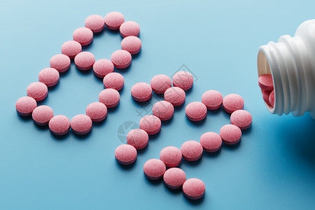 钴胺素粉色药丸 以字母B12的形状 在蓝色背景上 从白色罐头溢出药品药店治疗制药营养剂量健康食物颗粒木头背景