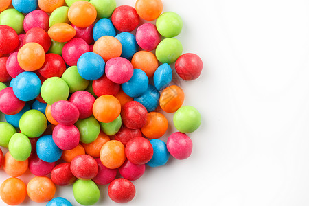 彩色糖果的彩虹色特写 白色背景上的多色釉糖衣丸团体圆圈巧克力孩子涂层宏观甜点甜心食物蜜饯背景