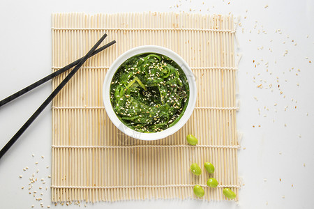 白碗中的瓦卡梅沙拉植物芝麻美食鱼片海藻盘子叶子海鲜藻类图片