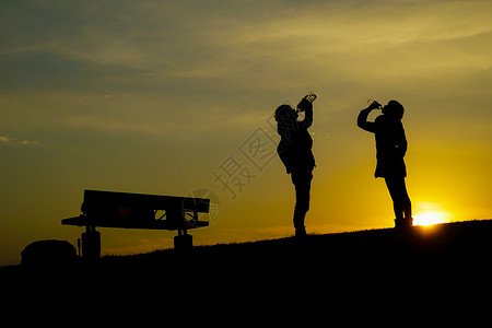 三鹰之森男男女女在黄昏山丘上饮水公园水分太阳供水爬坡阴影饮用水背景男人三鹰背景