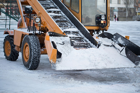 犁拖拉机从雪中清理道路 挖掘机清理城市大量积雪的街道清洁工机器天气卡车路人车道车轮风暴鼓风机男人背景