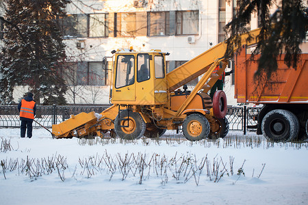 拖拉机从雪中清理道路 挖掘机清理城市中大量积雪的街道 工人在冬天从道路上扫雪 从暴风雪中清洁道路路面机器雪机男人看门人鼓风机雪堆背景图片