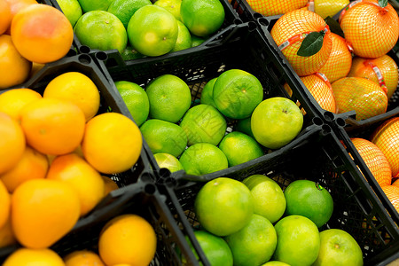 绿色盒子新鲜的柑橘在商店的货架上 各种柑橘类水果 橙子 橘子 酸橙 柠檬 超级市场热带柜台市场篮子柚子团体情调异国农业销售背景
