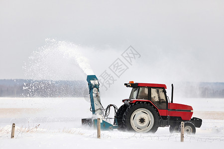 在农村布局中 红拖风雪吹着一条车道机器风暴打扫雪堆工作季节降雪耕作投掷者服务背景图片