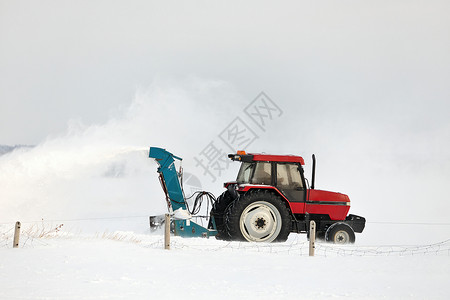 在农村布局中 红拖风雪吹着一条车道服务投掷者打扫耕作雪堆车辆机械季节工作暴风雪背景图片