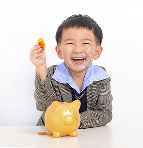 带着硬币和小猪银行的快乐男孩高清图片