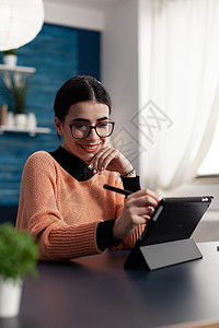 触控笔带着戴着触摸平板电脑展出的花样的眼镜微笑的学生背景