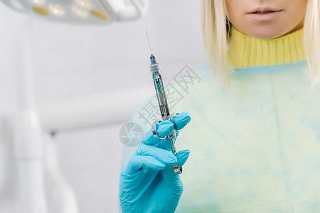 牙医在办公室为病人拿着注射器生物健康诊所化学注射医生面具危险医院蓝色图片
