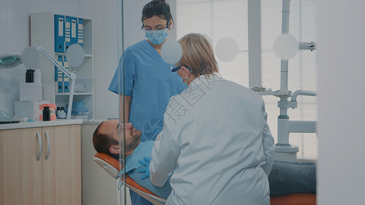口腔护理手术后检查牙齿的医生和护士图片